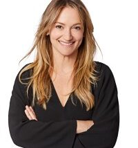 Rachel Delphin, Twitch's Chief Marketing Officer, poses with her arms crossed in front of a blank white background.
